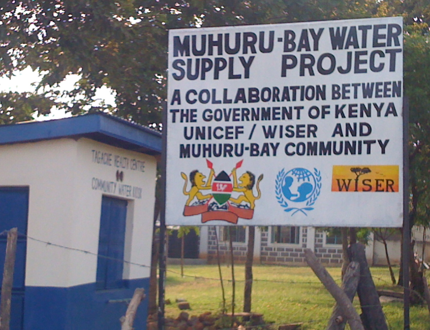 WISER girls laughing and smiling as they hold cups of clean water.