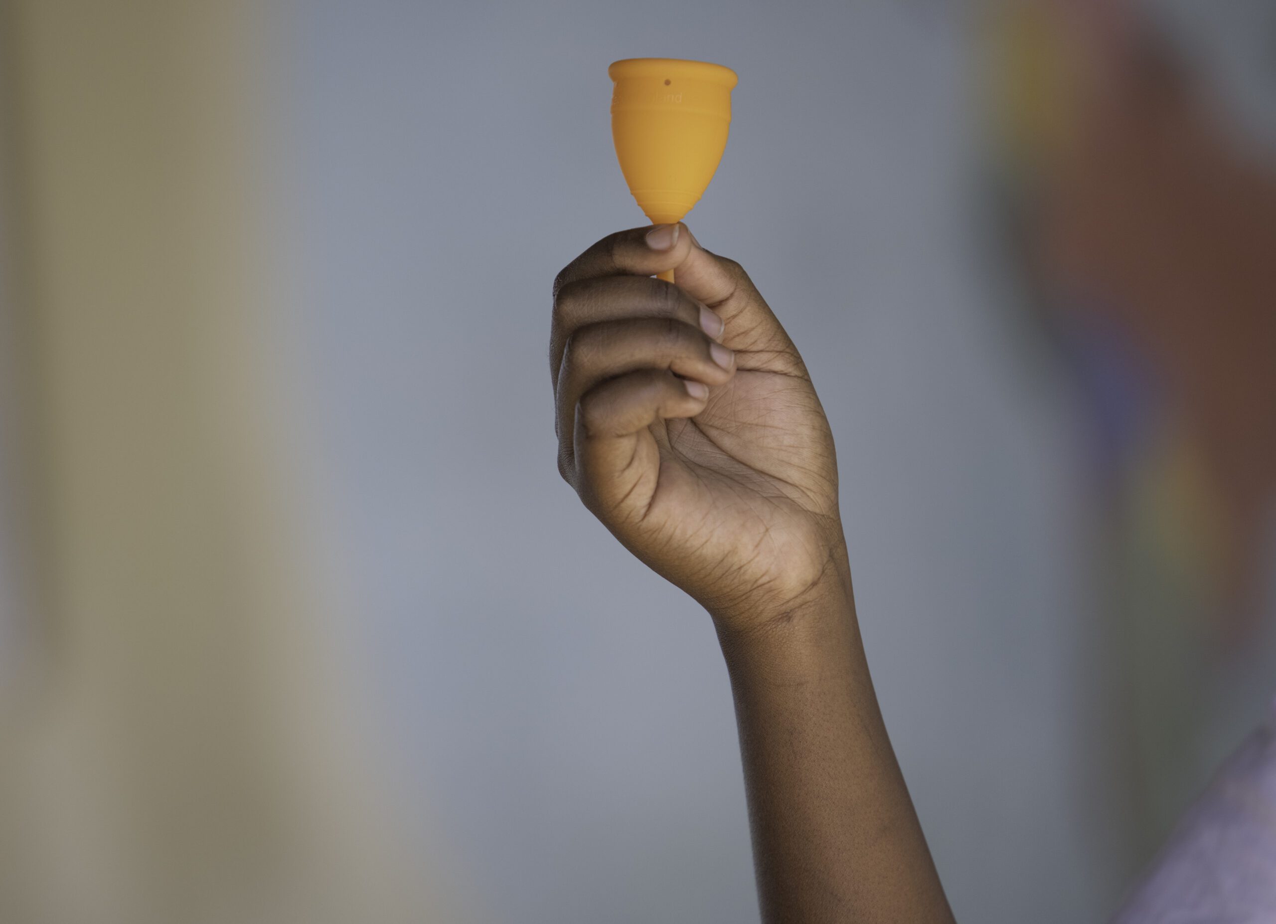 A hand holding a menstrual cup.